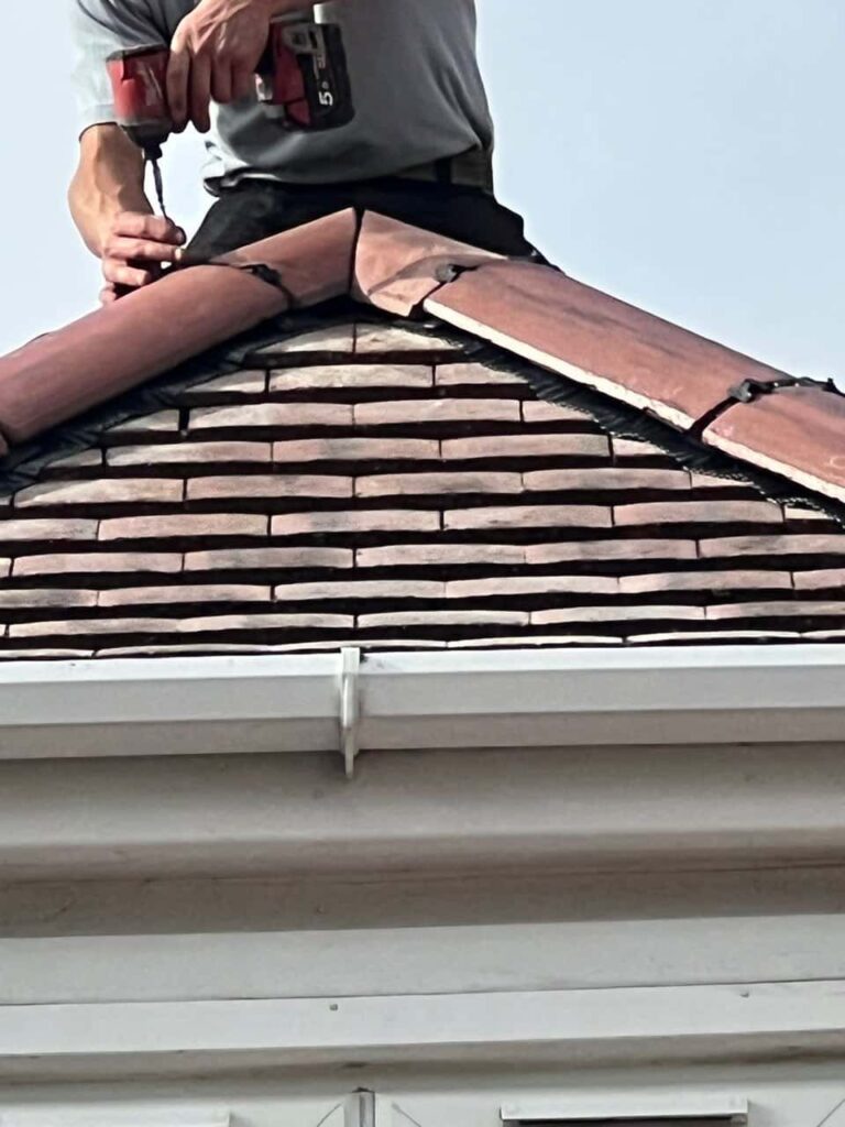 This is a photo of one of the operatives of Newark on Trent Roofing Repairs installing new ridge tiles