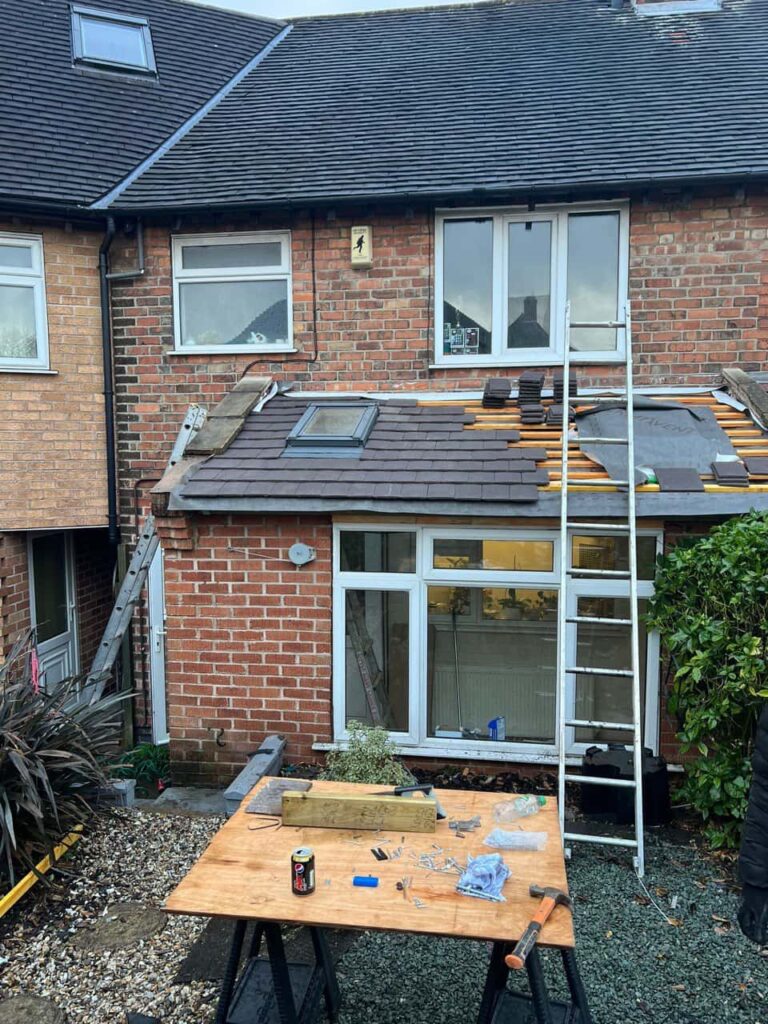 This is a photo of a roof extension that is having new roof tiles installed. This is a photo taken from the roof ridge looking down a tiled pitched roof on to a flat roof. Works carried out by Newark on Trent Roofing Repairs