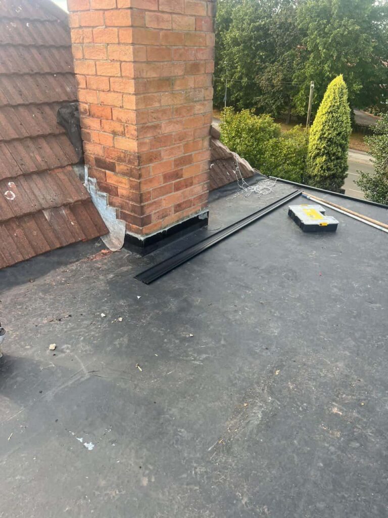 This is a photo of a flat roof which has just been repaired, there is also a chimney stack and some leadwork has also been dressed. Works carried out by Newark on Trent Roofing Repairs